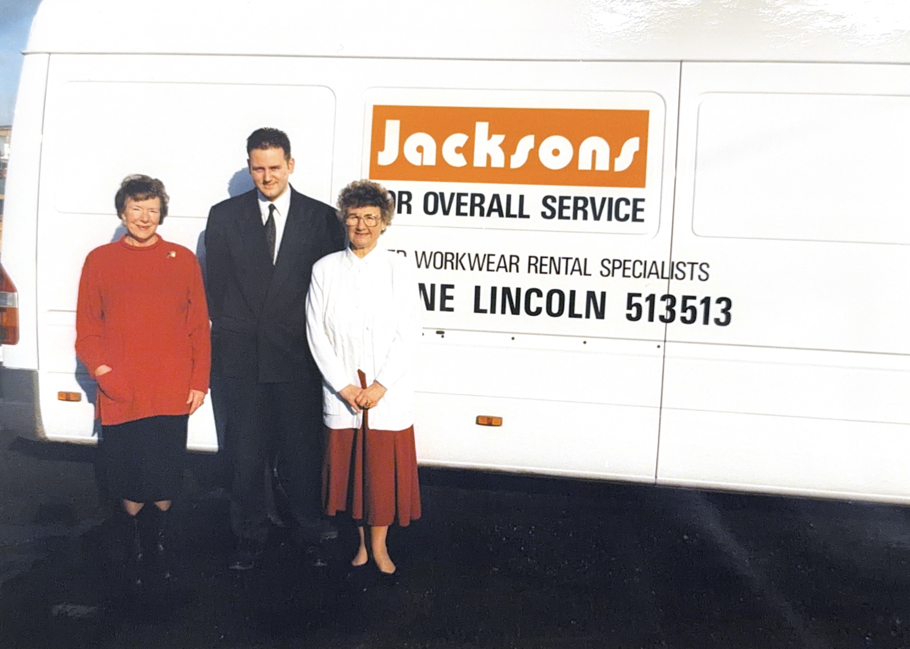 Three people stood in front and too the side of a white Jacksons Workwear branded van