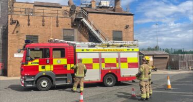 Firemen stood by a fire engine about to run a drill