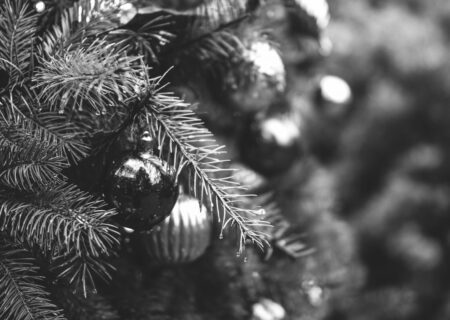A zoomed in image of a Christmas tree with decorations on