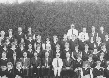 All of Jacksons staff circa 1990 posing for a photo with large bush in the background.